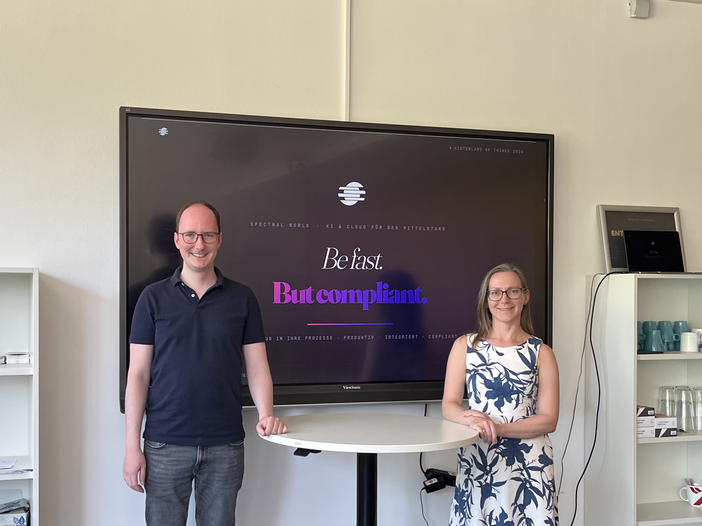Marco Kellmann and Spasimira Goncheva-Kompa in front of a Spectral World GmbH presentation slide reading Be fast. But compliant.